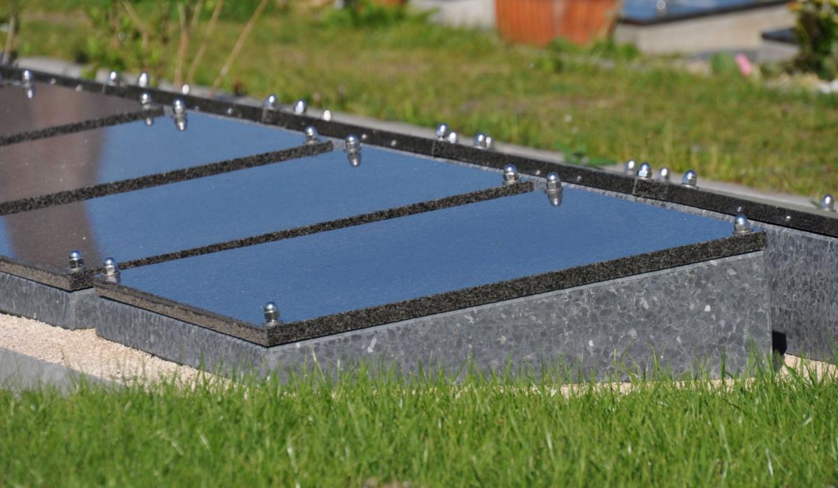 Kunststof urnenkelder lessenaardeksel beton naamplaat graniet jasberg closeup